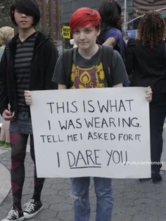 a young boy holding a sign that says, this is what i was wearing tell me asked for it, i dare you