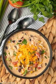 an image of a bowl of soup with cheese and black beans on it next to some vegetables