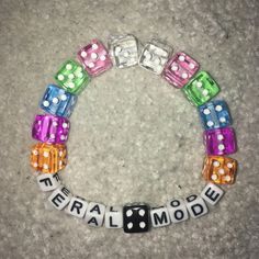 a close up of a bracelet made out of dices and beads with words on it