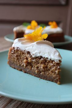 a piece of cake with white frosting and yellow flowers on top is sitting on a blue plate