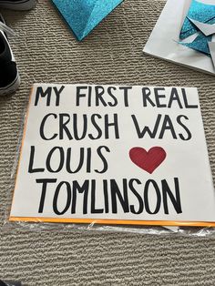 a sign on the ground that says my first real crush was louis tomkinson