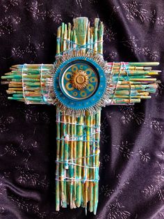 a cross made out of sticks with a sun on the center and an intricate design