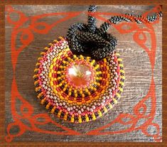 a beaded necklace with an orange, yellow and black bead on the front