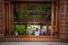 the bride and groom are kissing in front of an open doorway at their wedding ceremony