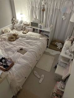 there is a bed with white sheets and teddy bears on the pillows in this room