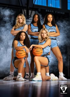 a group of young women standing next to each other holding basketballs