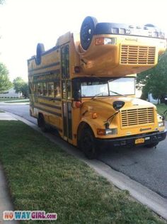 a yellow school bus is parked on the side of the road in front of some grass