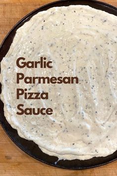 A pizza crust covered in white sauce on a pizza pan. Garlic Cream Pizza Sauce, Creamy Garlic White Pizza Sauce, Types Of Pizza Sauce, How To Make White Pizza Sauce, Garlic Parm Pizza Sauce, Best White Pizza Sauce, Ranch Sauce For Pizza, How To Make A White Pizza, Garlic Sauce For Pizza Crust