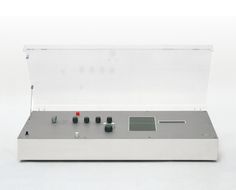 an electronic device with buttons and knobs in a clear case on a white surface