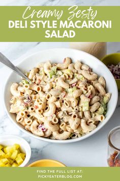 a bowl filled with macaroni salad next to other bowls