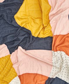 an unmade quilt is laying on top of the bedding with polka dotes