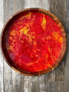 a wooden bowl with red and yellow paint on it