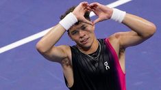 a male tennis player is holding his hands to his head