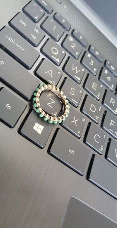 a ring is sitting on the keyboard of a laptop that has it's keys missing