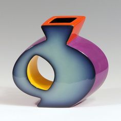 a colorful vase sitting on top of a white table