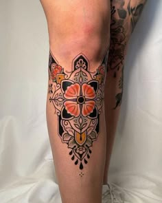 a woman's legs with tattoos on them and flowers in the middle of her leg