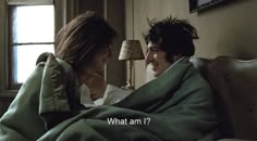 a man and woman wrapped up in blankets on a bed with the caption what am i?