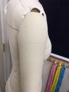 the back of a mannequin's torso with different colored pins on it