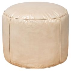 a large round leather ottoman sitting on top of a white floor