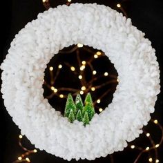 a white wreath with green trees on it