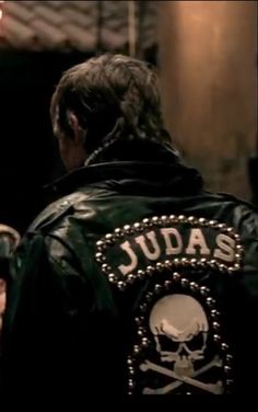 a man in a leather jacket with a skull and crossbones on his back