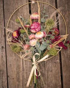 a bunch of flowers that are sitting in a vase on a table next to a wooden fence