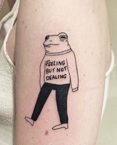 a woman with a tattoo on her arm that says feeling but not dealing, and a bear wearing a sweater