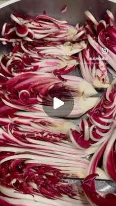 red onions being cooked in a pot with spoons