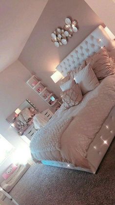 a bedroom with a large bed and lots of lights on the headboard in it