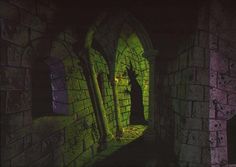 an image of a dark castle with light coming from the window and statue in the doorway