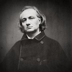 an old black and white photo of a man with long hair wearing a pea coat