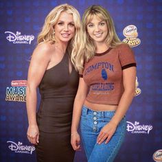 two women standing next to each other in front of a blue background with the words disney on it