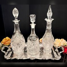 three glass decanters on a tray with flowers