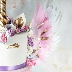 a white cake with pink, purple and gold decorations