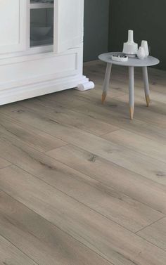 a living room with white furniture and wood flooring