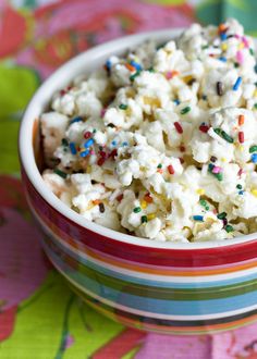 a bowl filled with white popcorn and sprinkles