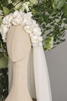 a headpiece with flowers and veil on top of a mannequin's head