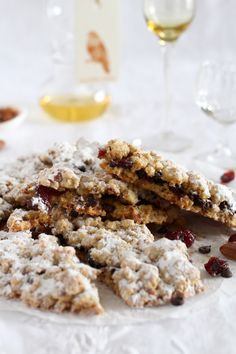 cookies and cranberries sit on a plate with wine glasses in the back ground