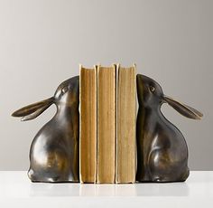 a bookend with two metal rabbits sitting next to each other