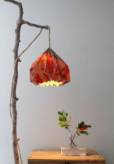 a lamp that is on top of a table next to a potted leafy plant