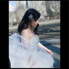 a woman in a wedding dress is walking down the street with her hand on her hip