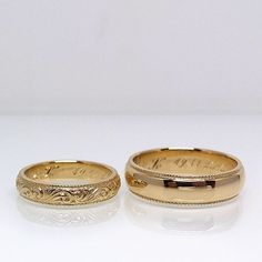 two gold wedding bands sitting next to each other