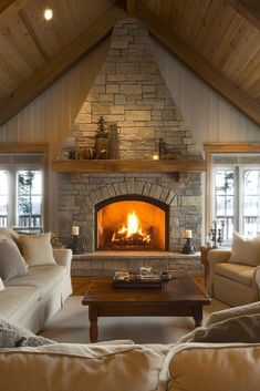 a living room filled with furniture and a fire place in the middle of a room