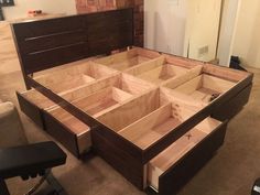 a wooden bed frame with drawers on the top and bottom part in place for storage