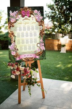 a sign with flowers on it sitting in the grass