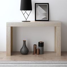 a table with two vases and a lamp on it next to other items in front of a white wall