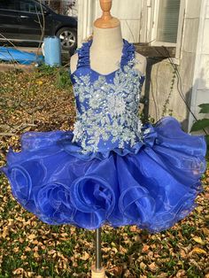 Beautiful blue glitz cupcake dress. Fits size 6-8. Features a corset back, elastic waistband on skirt and magnetic snaps to help hold the two together to prevent gapping. The top has a beautiful elastic ruffle halter with rhinestones along the edge, beautiful light blue appliqué flowers and rhinestones in the middle and a cute ruffle along the bottom. The skirt features an elastic waistband and plenty of layers of ruffles to give it the poof and pizazz that all dresses like this need. This is a Fitted Sleeveless Pageant Dress With Ruffles, Sleeveless Ruffled Pageant Dress, Summer Pageant Dress With Fitted Bodice, Fitted Ruffle Dress For Pageant, Fitted Ruffle Dress For Pageants, Sleeveless Fitted Pageant Dress For Summer, Summer Sleeveless Fitted Pageant Dress, Fitted Sleeveless Summer Pageant Dress, Fitted Sleeveless Pageant Dress