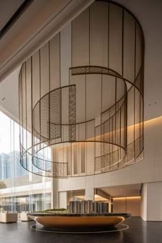 the inside of an office building with large glass walls and circular metal railings on the ceiling