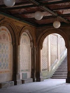 an empty room with stone steps and arches