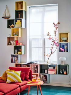 a living room filled with lots of furniture and bookshelves next to a window